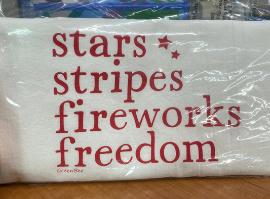 A white cotton kitchen towel with the text 'stars stripes fireworks freedom' printed in red.