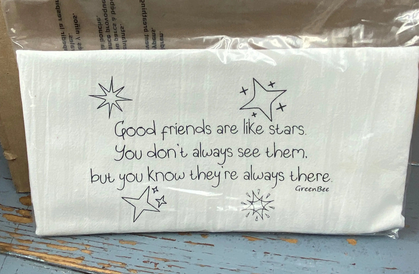 A white cotton kitchen towel with black text and decorative stars, Good friends are like stars. you don't always see them, but you know they're always there.