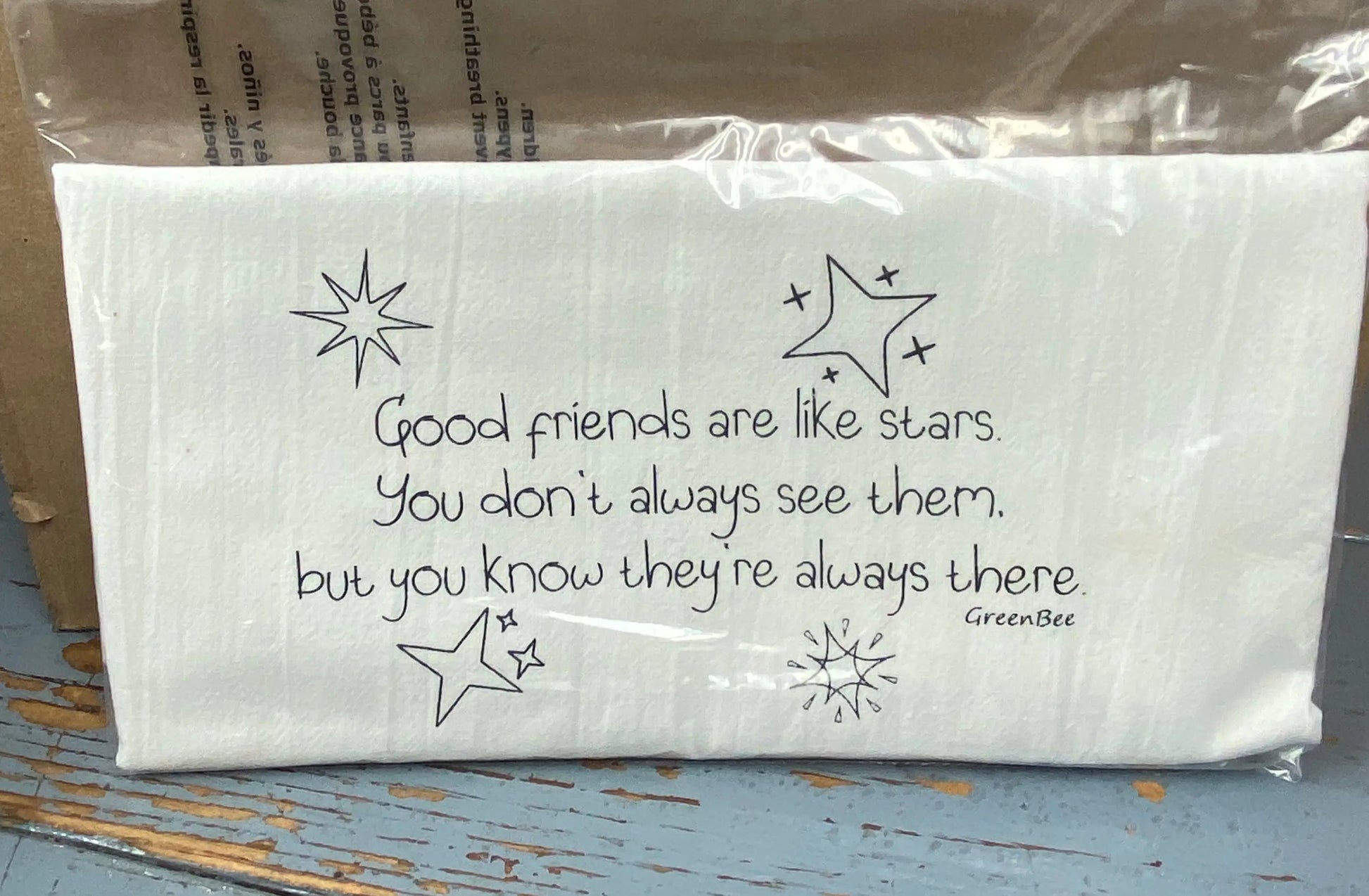 A white cotton kitchen towel with black text and decorative stars, Good friends are like stars. you don't always see them, but you know they're always there.
